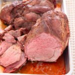 Cooked roast of lamb, sliced showing it is medium rare.